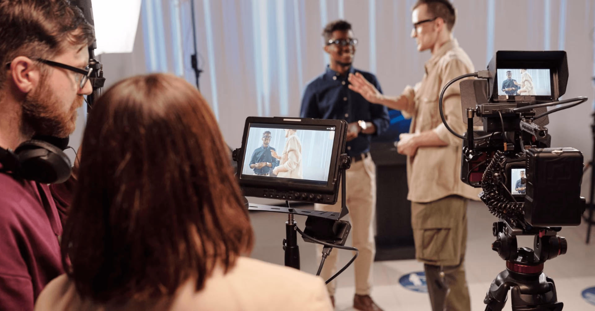 Film crew shooting a scene in a studio with cameras and monitors.