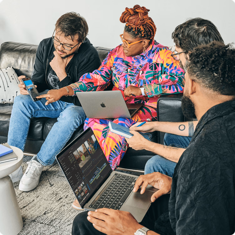 Four media and entertainment creatives collaborating on a project at a shared workspace, working on laptops and using LicidLink.
