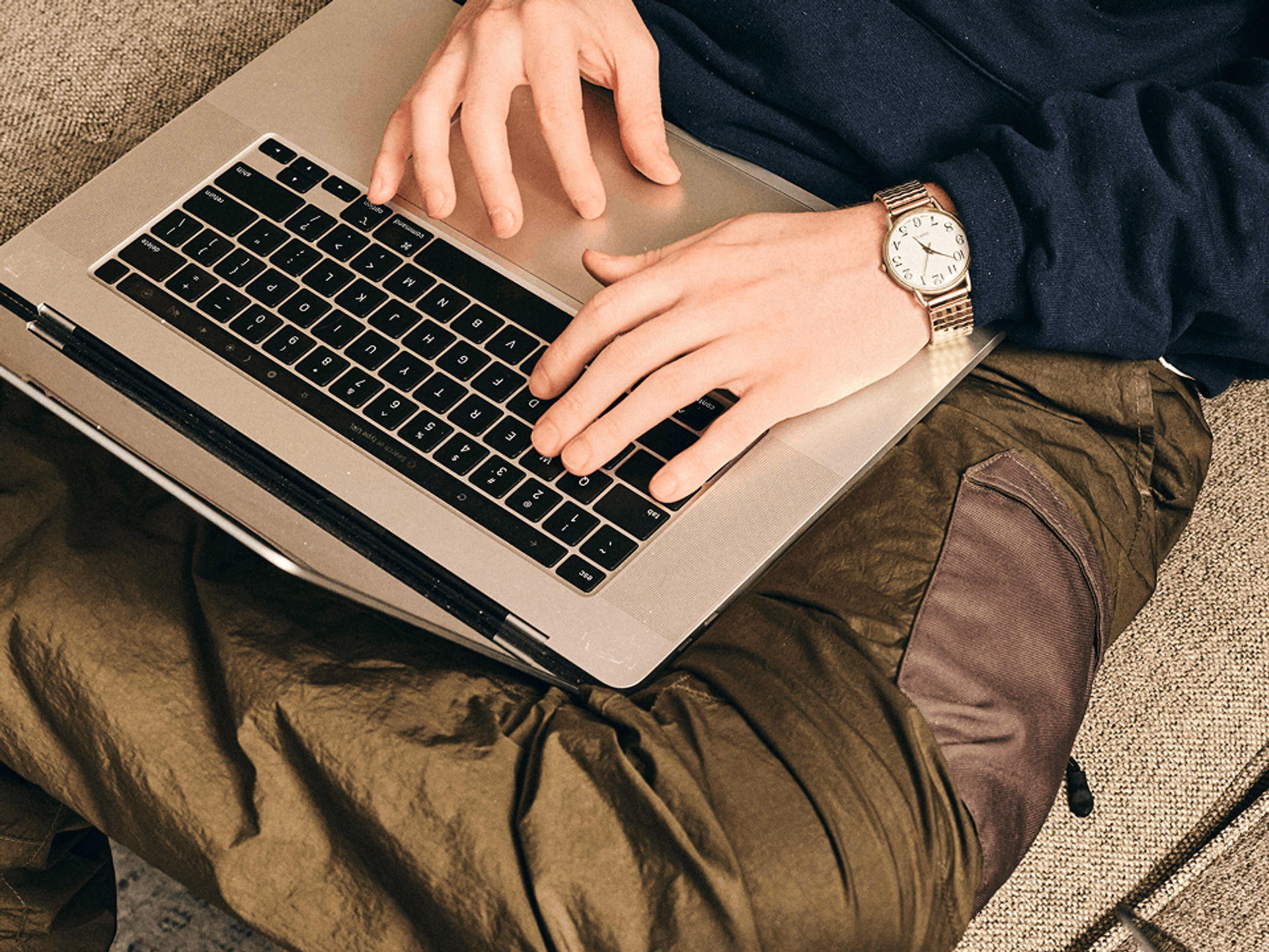 Person typing on a laptop on their lap.