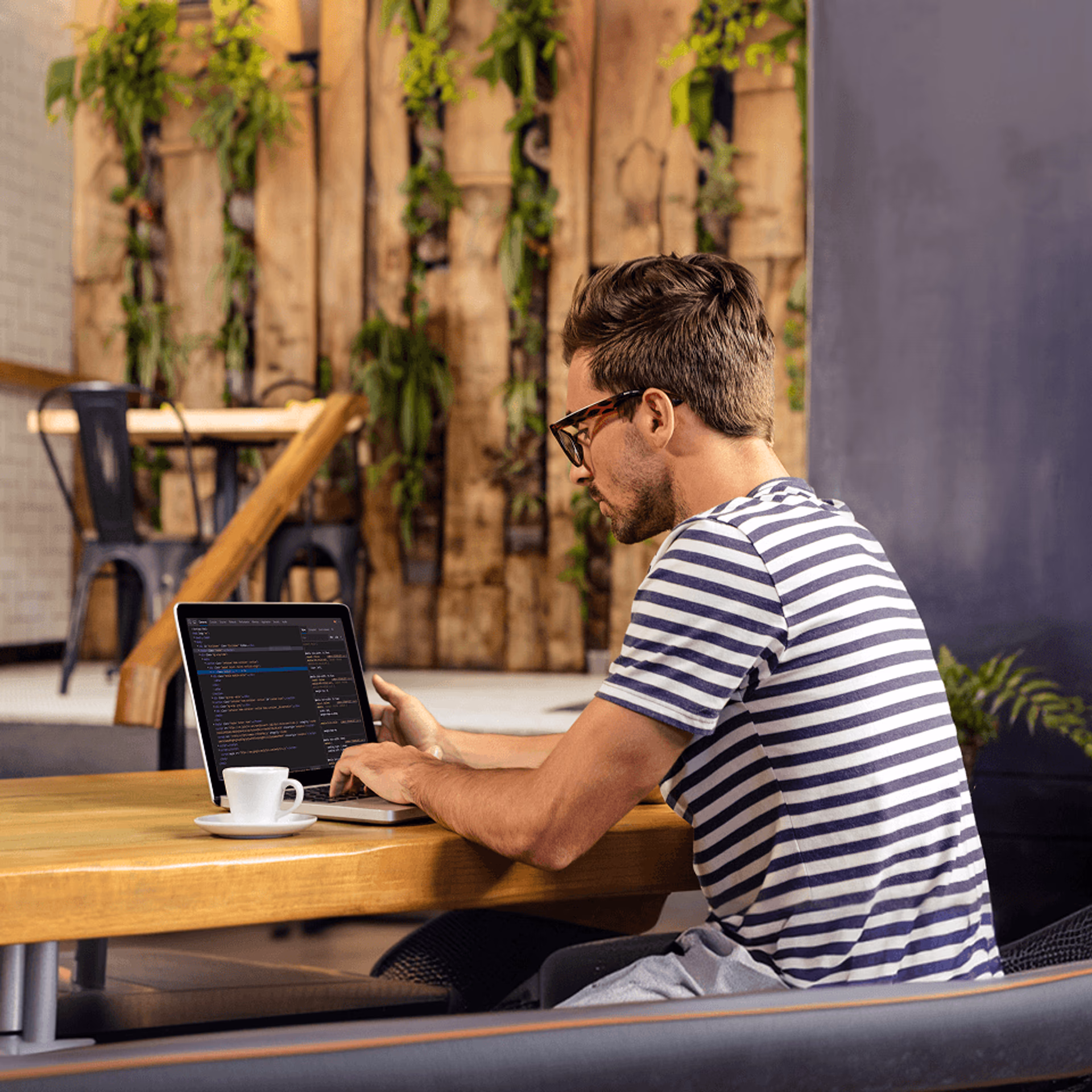 A man on a laptop on his desk at home.