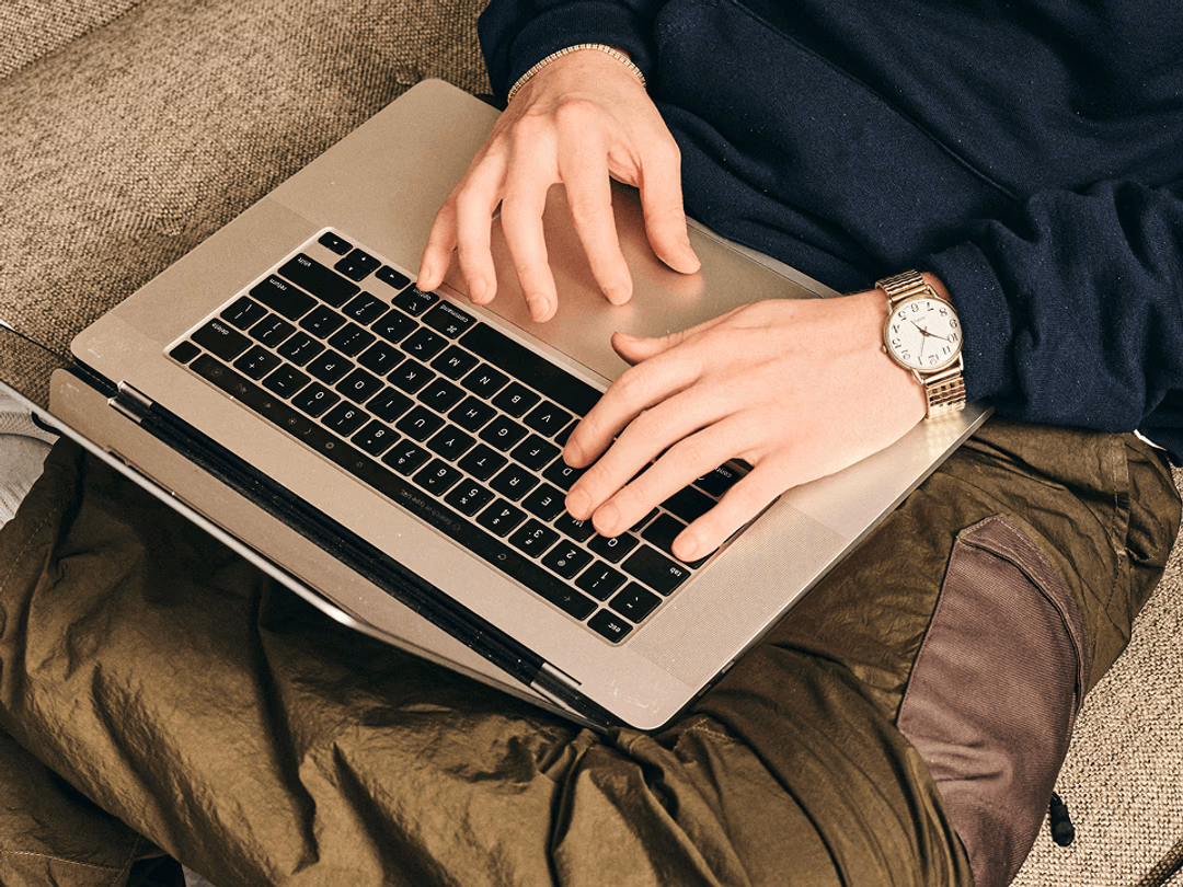 Person typing on a laptop on their lap.